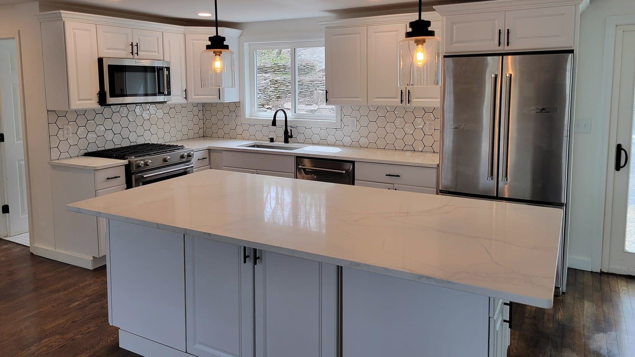 White kitchen with an island, hex-tile backsplash and pendant lights, Reading, a Brightwork project
